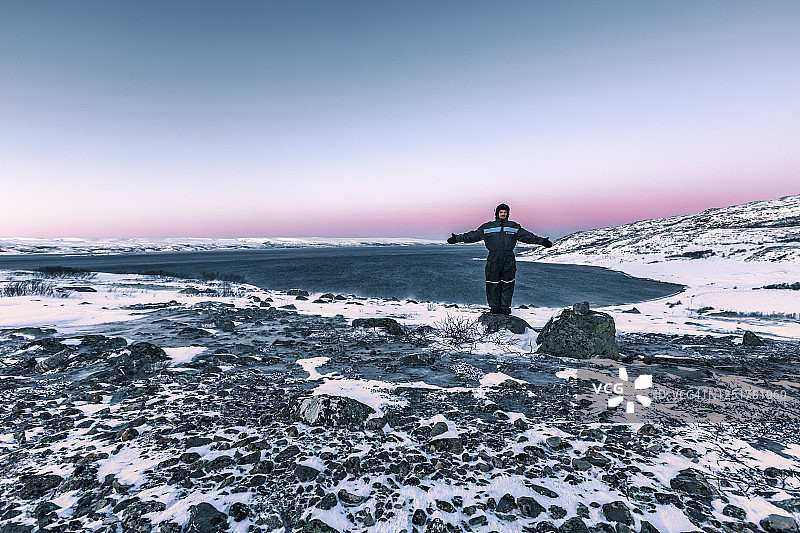 冬天，挪威勒贝斯比湖峡湾，一名男子站在海岸景观中图片素材