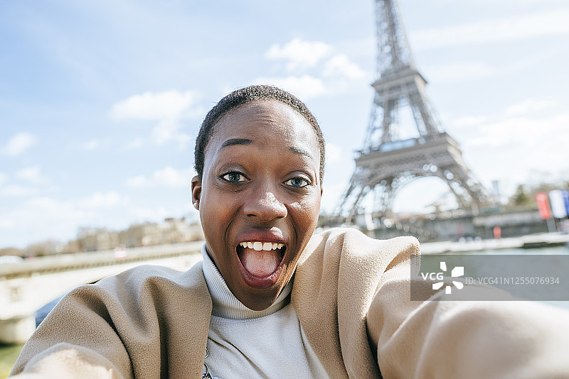 法国巴黎，一名震惊的女子以埃菲尔铁塔为背景自拍图片素材