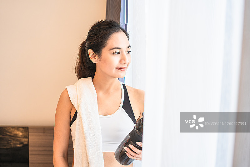 亚洲妇女微笑后，独自锻炼在家作为新的正常生活方式图片素材