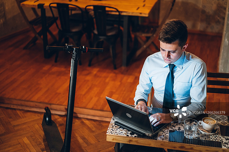 一个商人在咖啡馆用笔记本电脑工作图片素材