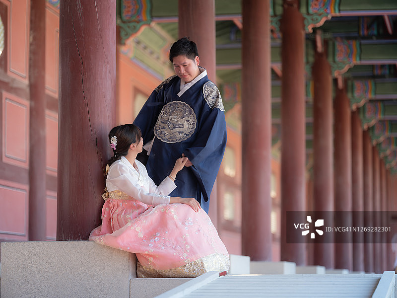 在韩国首尔的京福宫，亚洲游客穿着韩国传统服装图片素材
