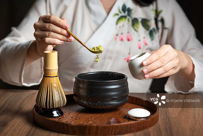 女人用传统的茶道用具制作抹茶绿茶图片素材