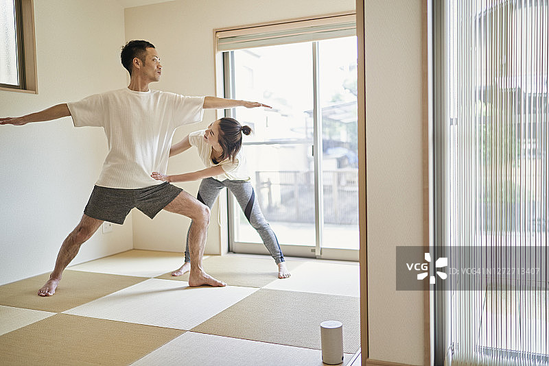 亚洲夫妇在日式室内做伸展运动。图片素材