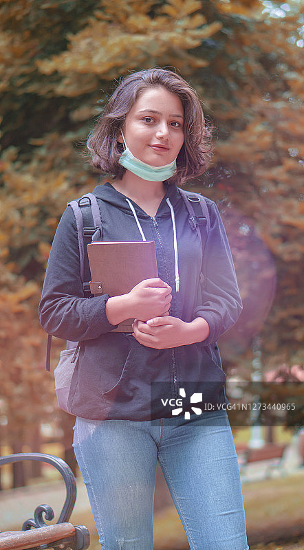 一名戴着医用口罩的女子在校园里的肖像。冠状病毒爆发，准备上课。图片素材