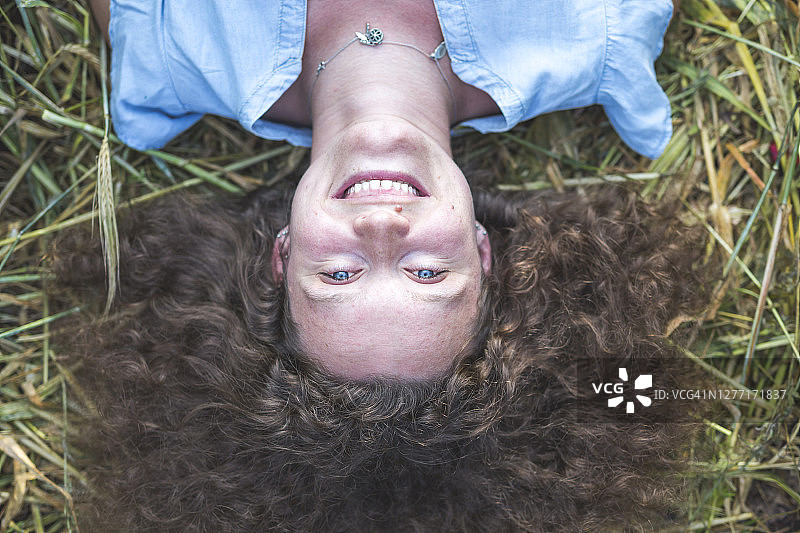 微笑的女人躺在农地上图片素材