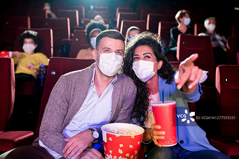 新冠肺炎大流行期间，一对夫妇在电影院看电影图片素材