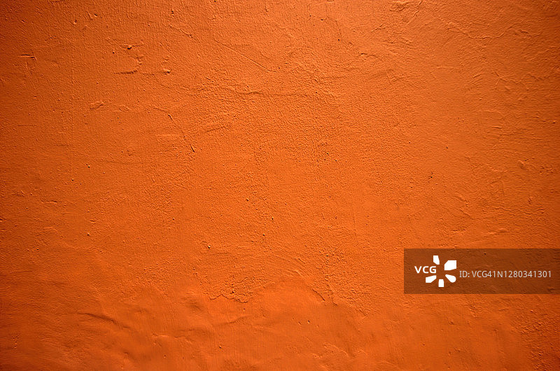 凹凸不平的建筑外墙粉刷成亮橙色图片素材