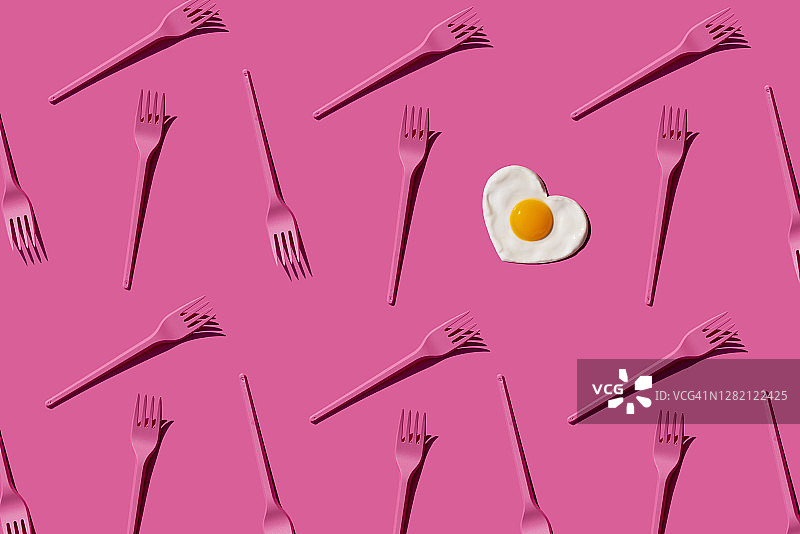 粉红色塑料叉子的图案与单心形状的煎蛋图片素材
