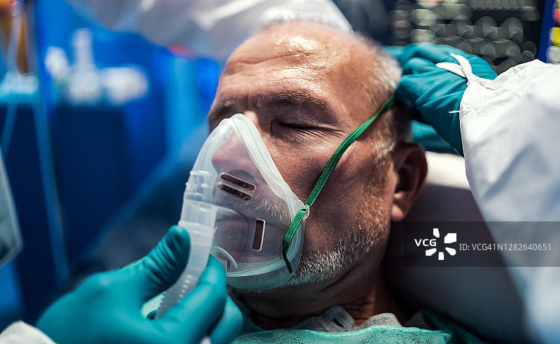 医生为住院的covid-19患者发放通风口罩，介绍冠状病毒概念。图片素材