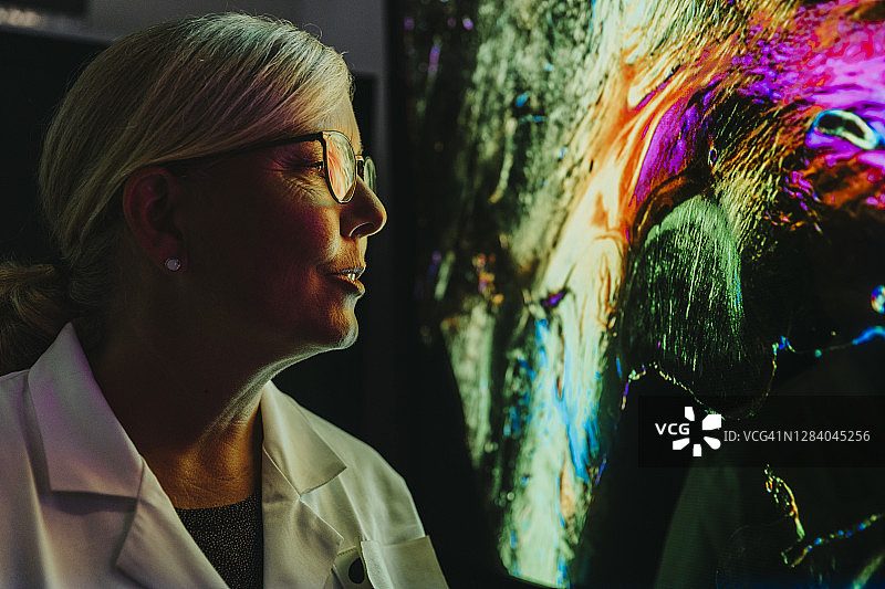 女科学家站在实验室里用神经纤维检查人类大脑的投影图片素材