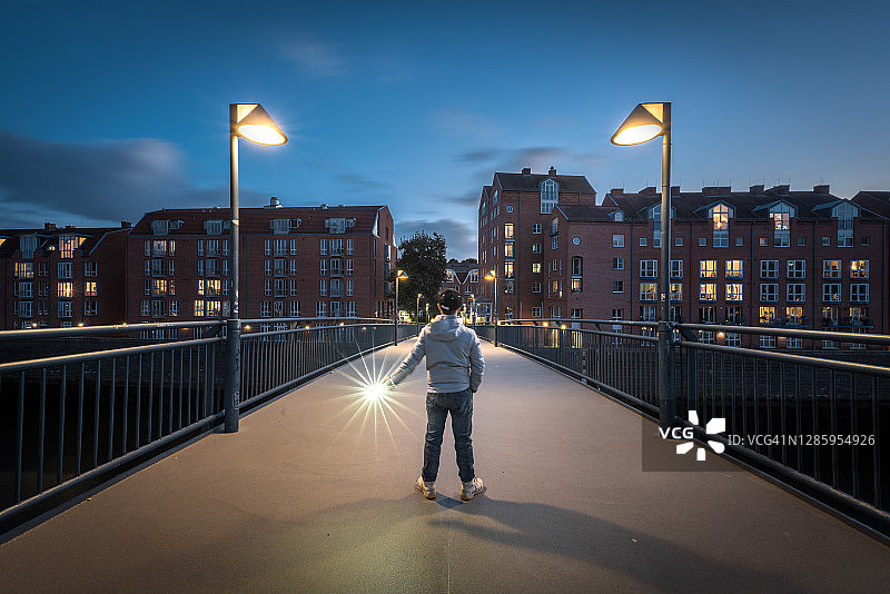 一个人晚上站在城市的桥上图片素材
