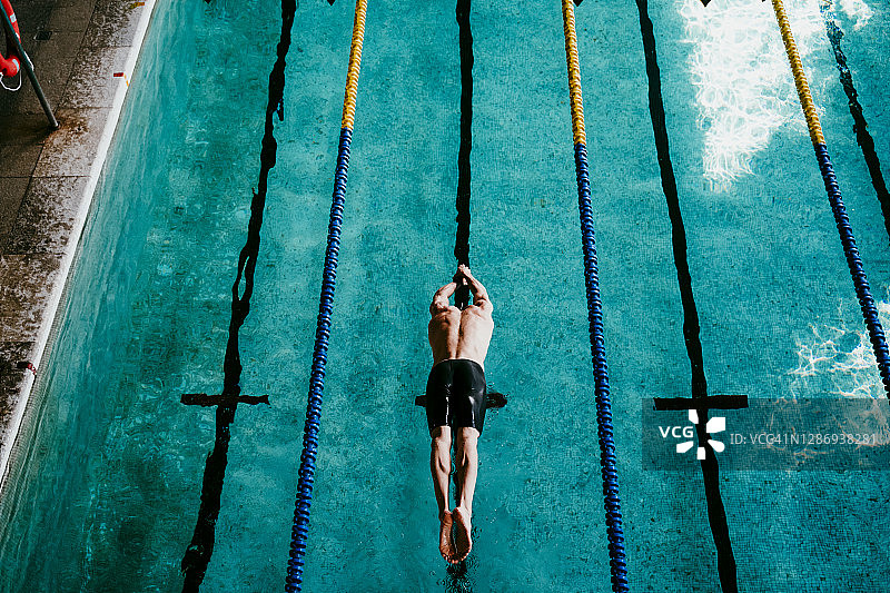 赤膊男游泳运动员在游泳池跳水图片素材