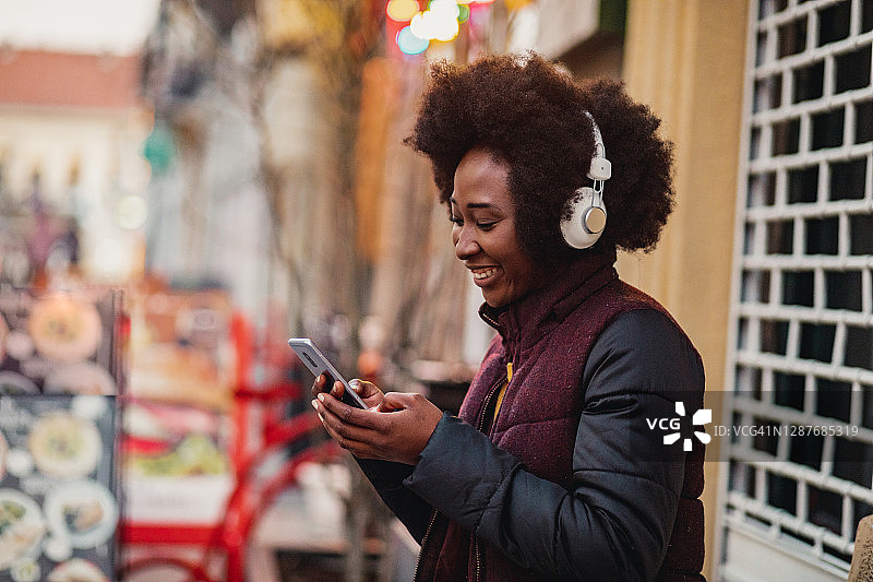 非裔美国妇女在街上听音乐的肖像图片素材