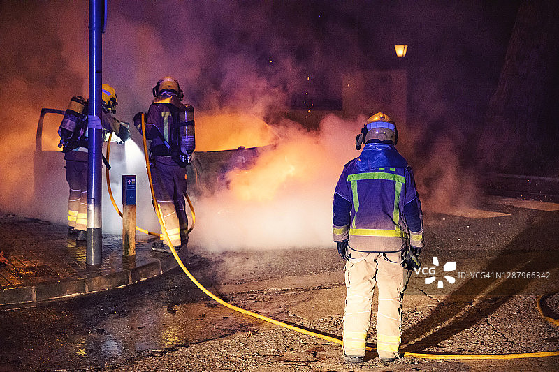 消防队员在夜间紧急灭火时采取的行动。图片素材