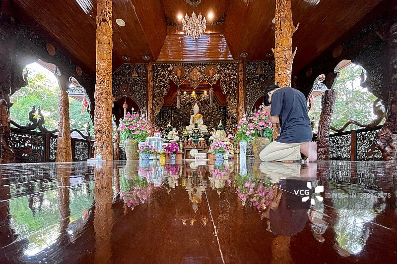 Pong Nam Ron旅游目的地- Wat Khao Chawang Temple的木制礼拜堂(内部)有美丽的木材渴望，大理石佛像和花卉装饰。图片素材