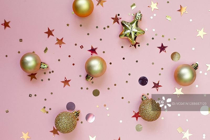 闪闪发光的金色小玩意儿和五彩纸屑。节日抽象粉色背景节日，新年，圣诞节。图片素材