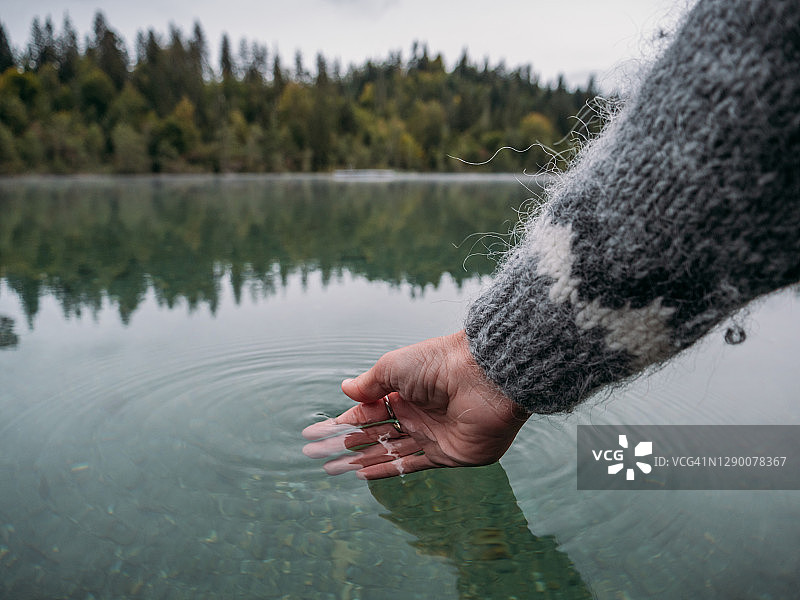 手从高山湖舀水图片素材