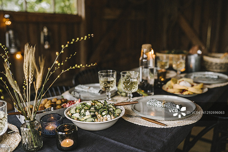 社交聚会时，将食物用碗、盘子和水杯摆放在餐桌上图片素材