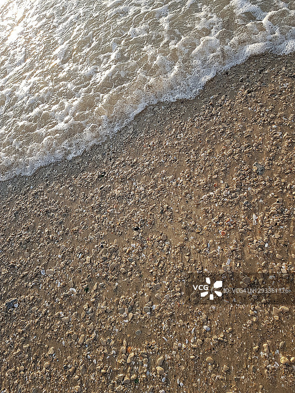 从海浪和沙子的极简主义观点，垂直特写图片素材