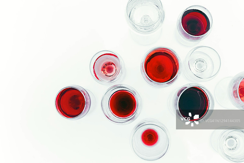 许多酒杯与不同的葡萄酒在白色的背景。图片素材