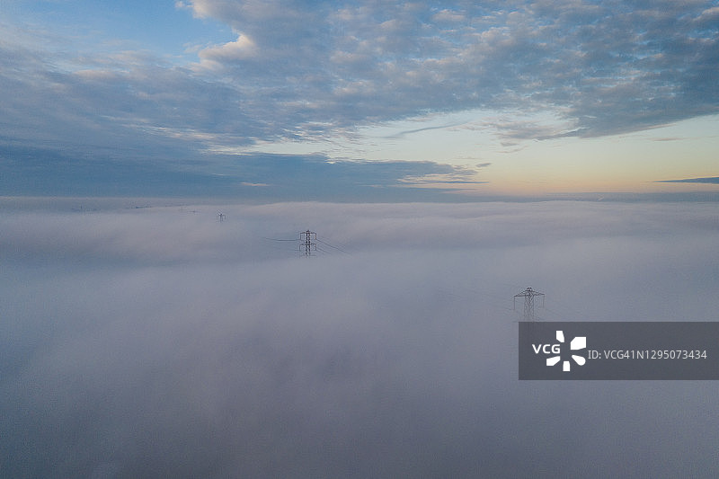 从空中俯瞰，一排塔伸出雾中，英国图片素材