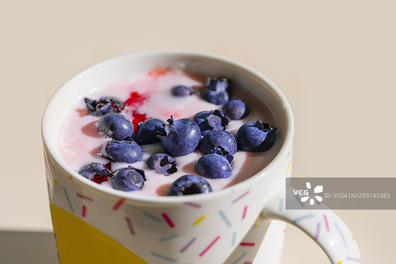 一碗燕麦片，蓝莓，草莓糖浆和牛奶图片素材