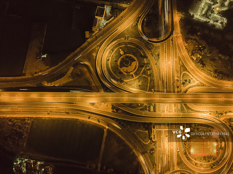 鸟瞰图，高速公路，高速公路或圆形运输道路运输在晚上或未来的概念。(金色调)图片素材