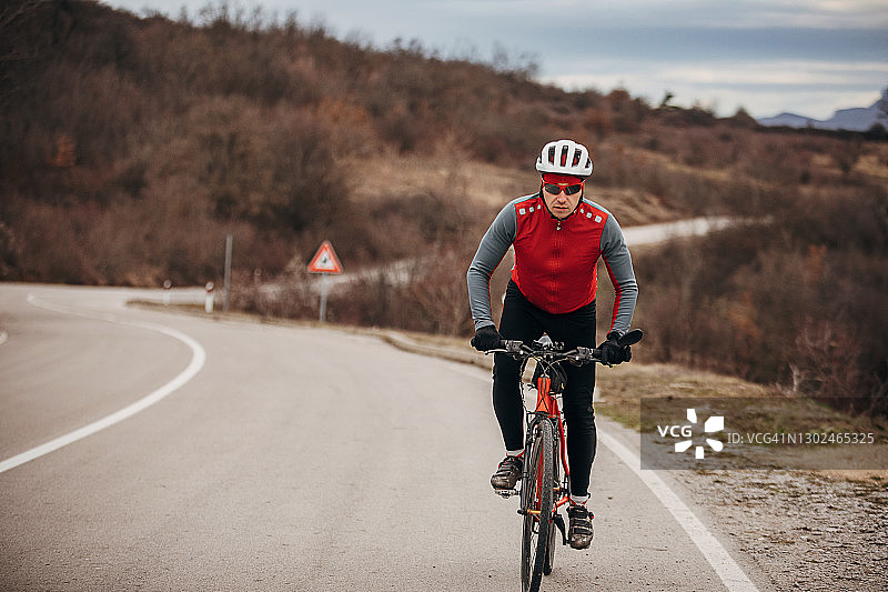 职业男性自行车手在路上骑自行车图片素材