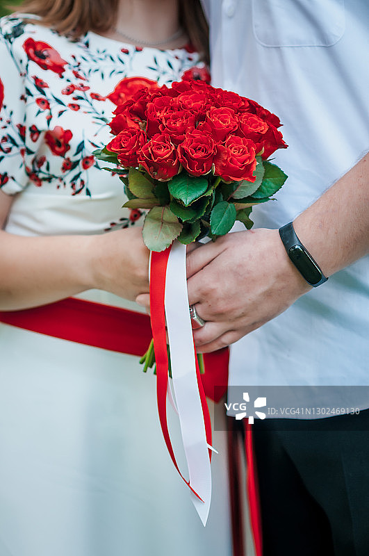 新婚夫妇手持一束红玫瑰图片素材