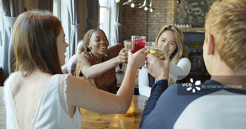 三个女人和一个男人在酒吧里祝酒图片素材