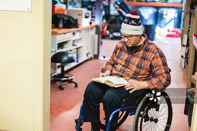 千禧一代残疾男性大学生在轮椅上工作和在工作中学习摄影系列图片素材
