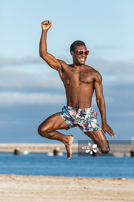 有趣的黑人在沙滩上跳图片素材
