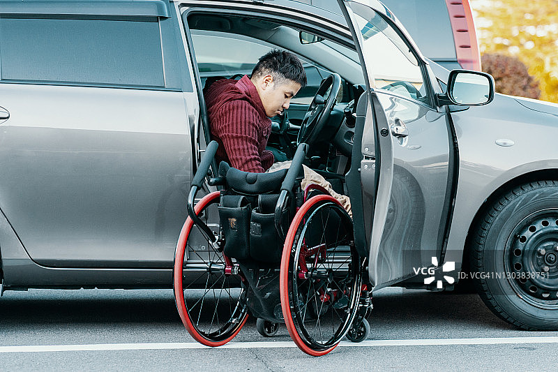 轮椅上的截瘫病人进出他的车图片素材