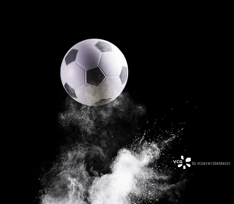 足球在黑色背景的地面上的撞击和反弹图片素材