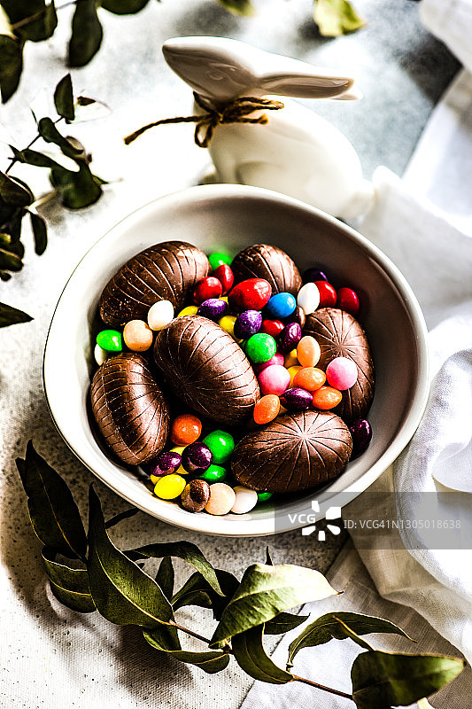 一碗混合巧克力复活节蛋和一个复活节兔子装饰图片素材