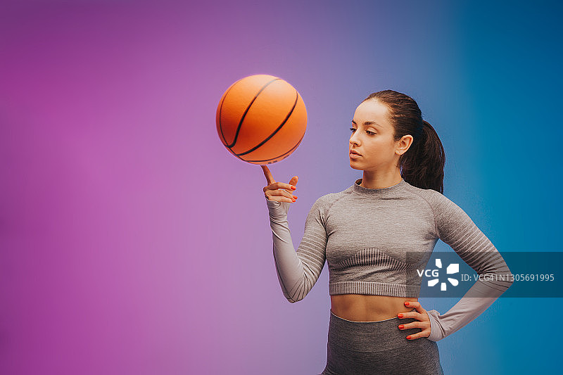 年轻的健康和运动的白人妇女的时尚肖像与篮球在梯度的背景。完美的身材为夏天做好了准备。美容、度假、运动理念图片素材