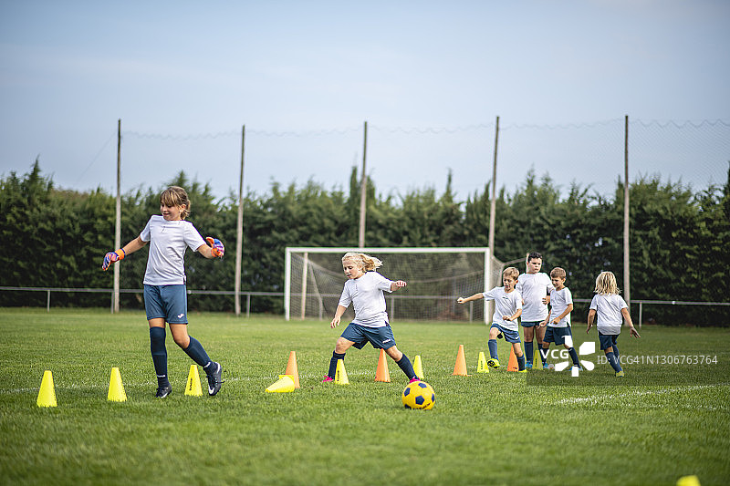 年轻的女孩和男孩足球运动员发展敏捷技能图片素材