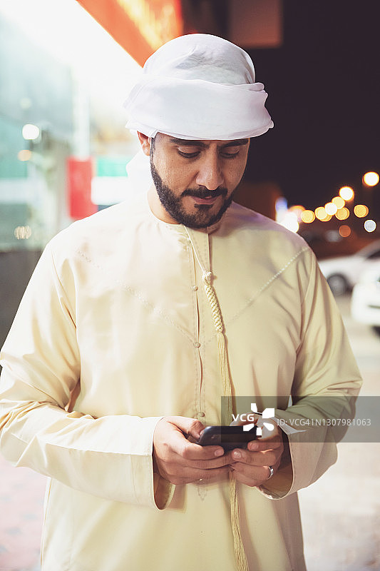阿拉伯人在咖啡馆外使用智能手机图片素材
