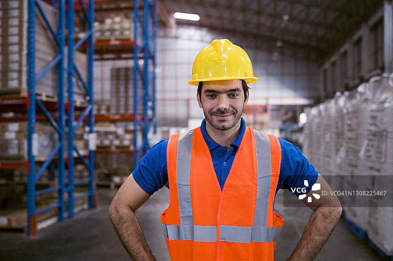 一个仓库工人站在一个大仓库里的肖像图片素材