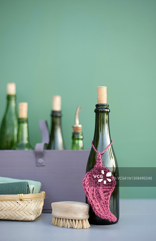 DIY清洁用品的绿色复古瓶，yute纱线钩针抹布，棉抹布和木刷图片素材