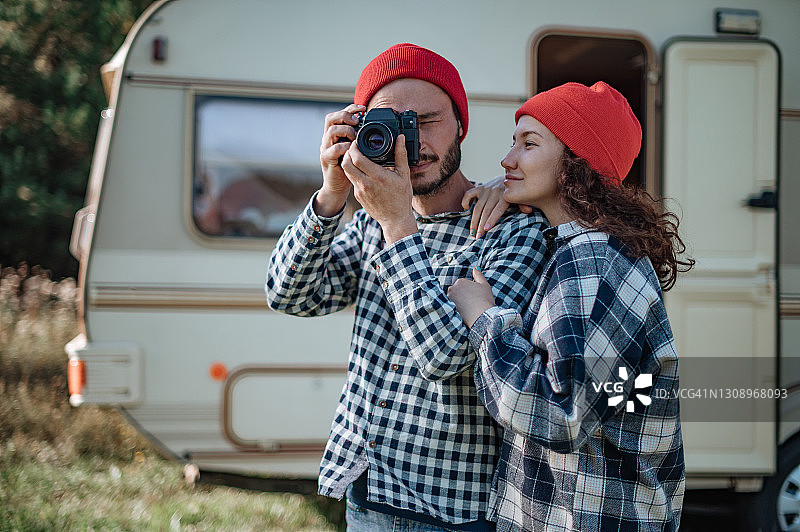 一对浪漫的夫妇带着照相机在家附近的拖车。图片素材
