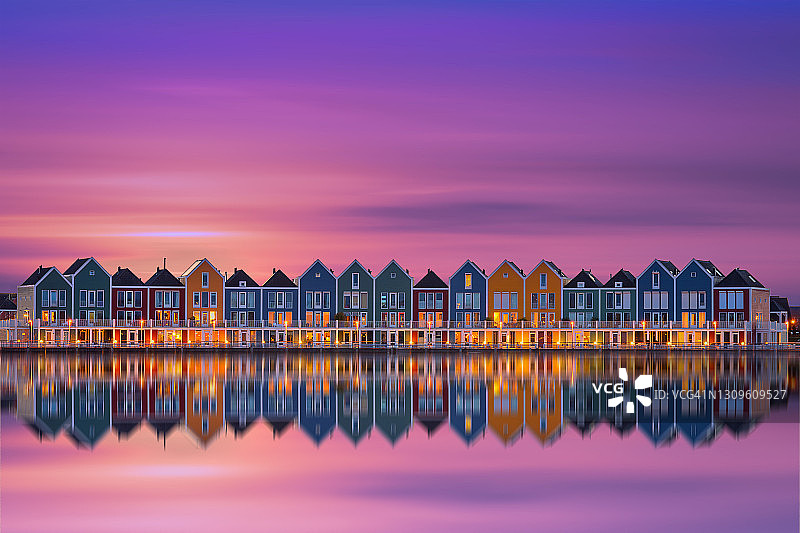 日落时，彩色的房屋倒映在湖面上图片素材