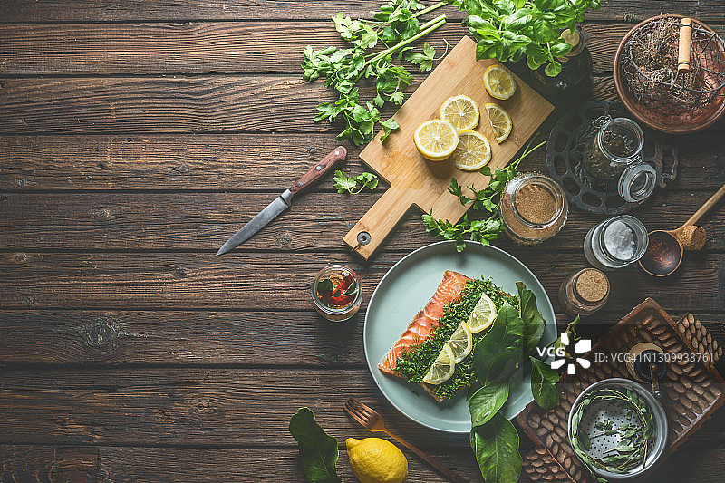 三文鱼配绿色的莳萝。在木桌上准备各种老式厨房用具和新鲜的食材图片素材