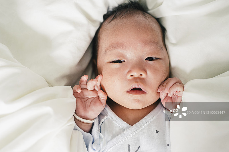 肖像面部表情topview亚洲新生儿在舒适的床上图片素材