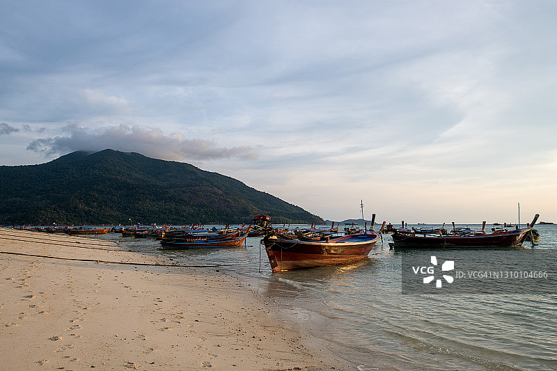 日落和日出在泰国的海滩与长尾船图片素材