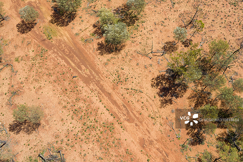 无人机俯瞰澳大利亚内陆的红土、土路和零零碎碎的绿色植物图片素材