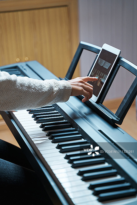 女子在网上学习弹钢琴。图片素材