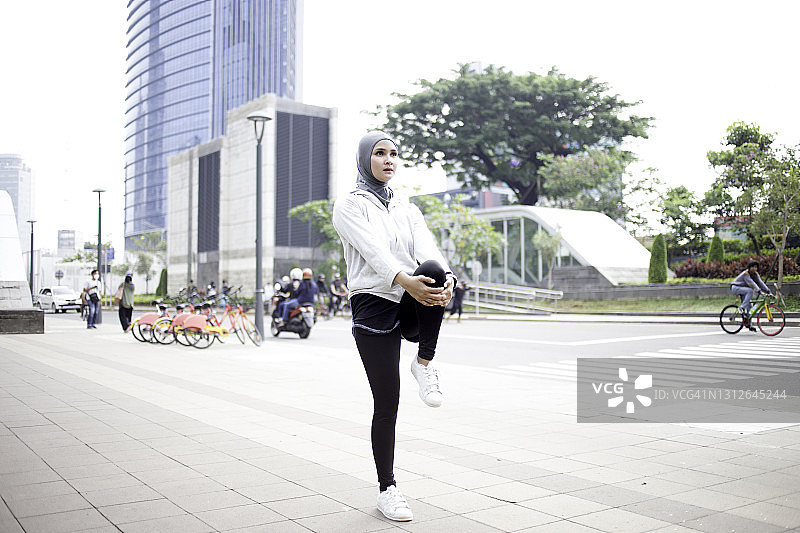 年轻的亚洲妇女希贾布伸展穿着运动服图片素材