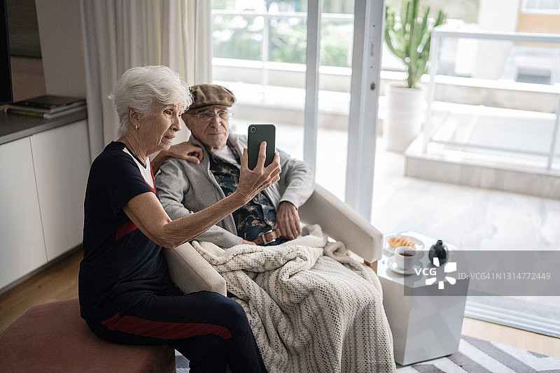 老夫妇在家里用智能手机打视频电话图片素材