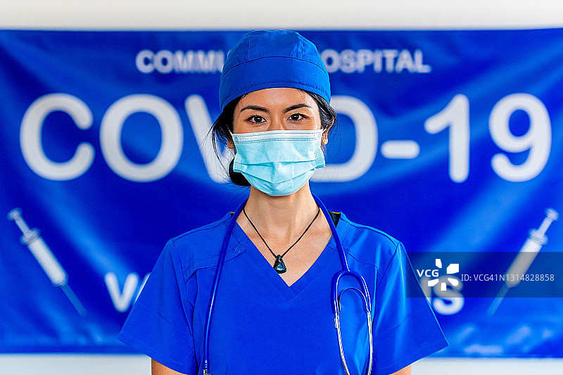 亚洲女性医护人员戴着防护口罩在covid-19疫苗接种点工作图片素材